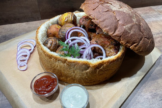 Хлебная тарелка с шашлыком из свиной шеи и картофелем на мангале
